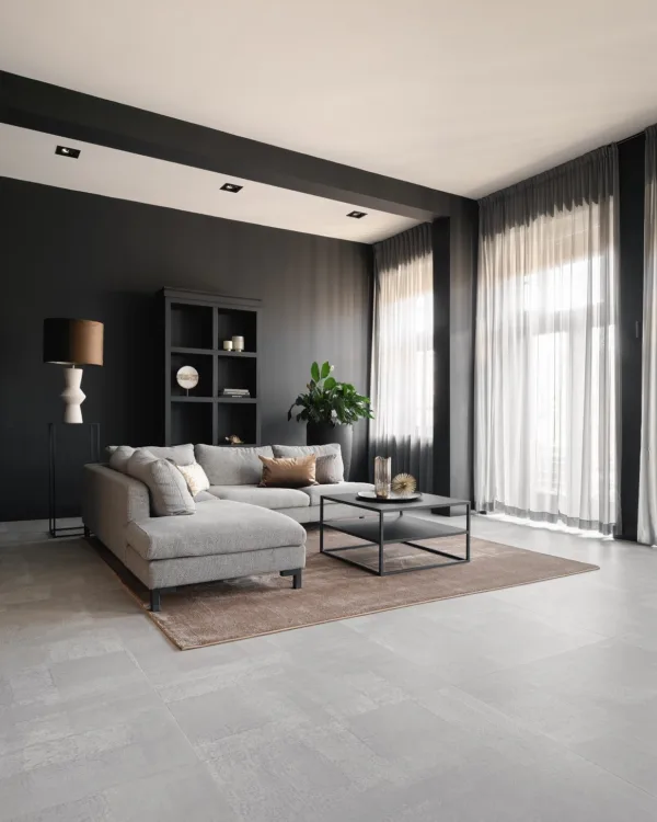 Woonkamer met lichtgrijze tegelvloer en moderne meubelen.