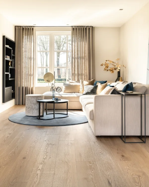 Woonkamer met Therdex vinyl vloer, sfeervolle gordijnen en knusse bank.