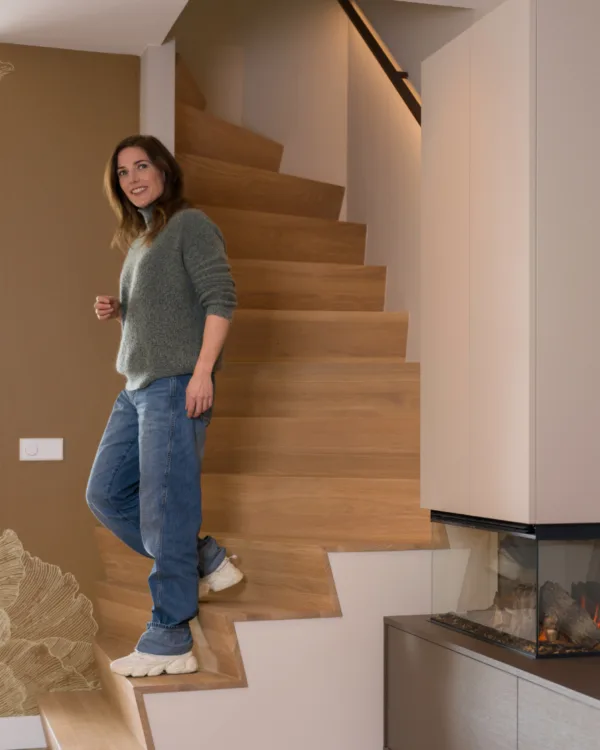 Licht eiken Z-trap in de woonkamer met een dame er op