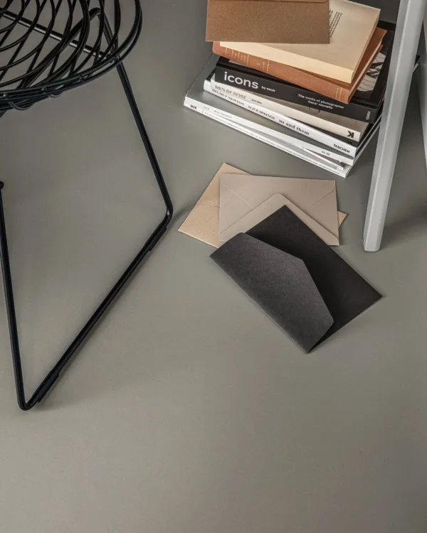 Licht grijze marmoleumvloer met een zwarte, stalen stoel