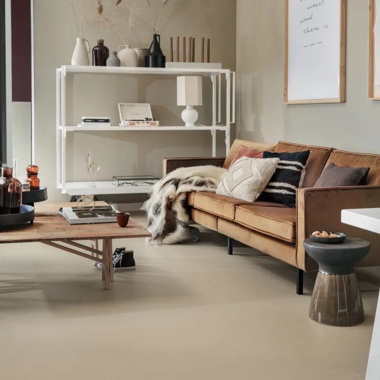 Bruine Marmoleum vloer van Forbo in een woonkamer met een bruine bank en een houten tafel.