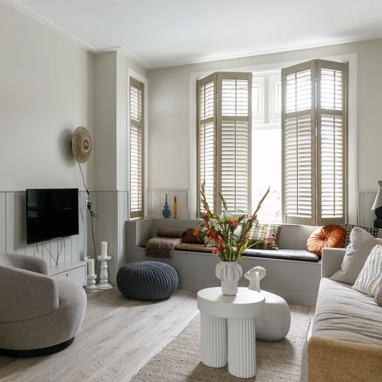 Woonkamer met knusse meubels en donkere kleuraccenten. Aanhuis.be