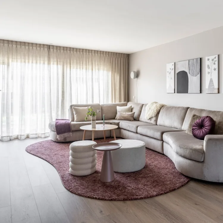 Woonkamer in lichte kleuren en houten vloer. Aanhuis.be