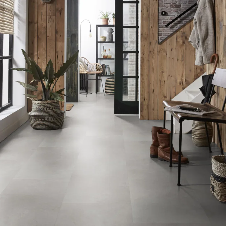 Hal met grijze vloer, houten lambrisering en stalen kozijnen passend bij de industriele woonstijl.