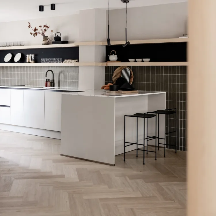 Keuken met visgraat vinyl, lichtrijze kasten en prachtige tegels op de muur.